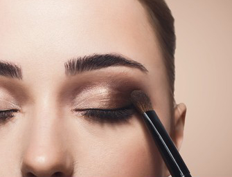 Woman applying her own eyeshadow for her wedding. DIY tips to do your own makeup for brides.