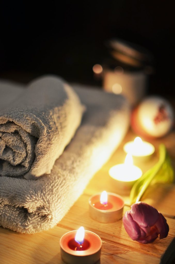 photo of spa like retreat with towels neatly folded and candles, creating a tranquil environment.