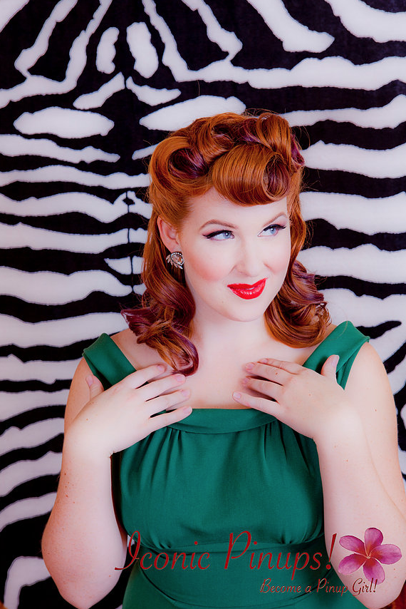 Photo of retro pinup girl with red hair, and a vintage hairstyle with victory rolls